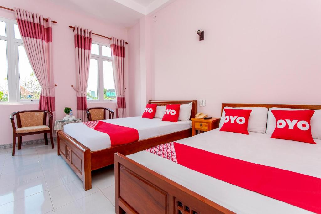 - une chambre avec 2 lits dotés d'oreillers rouges et blancs dans l'établissement OYO 962 Tulip Motel, à Đà Nẵng