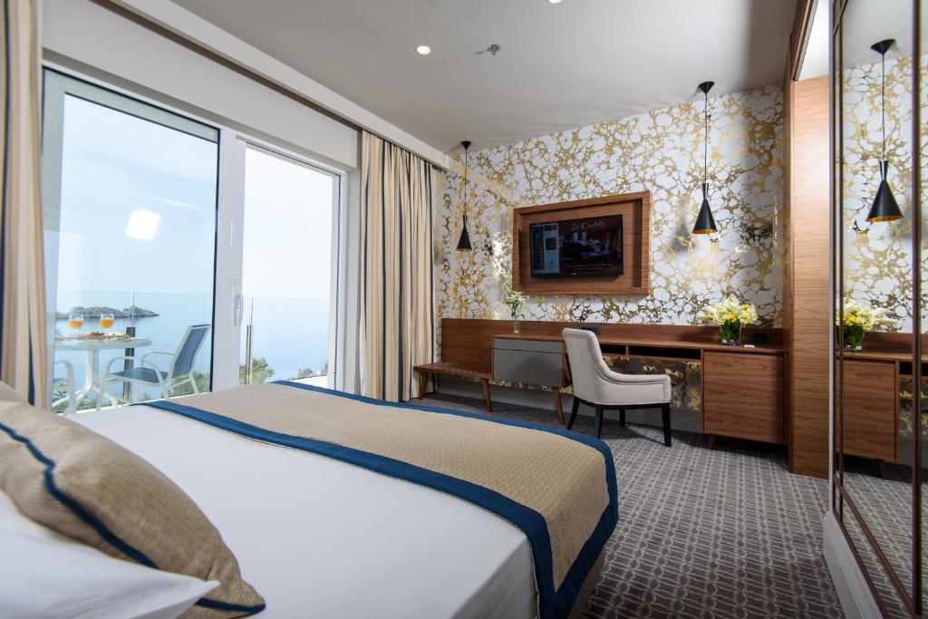 a hotel room with a bed and a desk at Royal Neptun Hotel in Dubrovnik