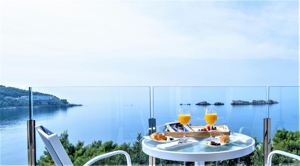 a table with two glasses of orange juice on top of it at Royal Neptun Hotel in Dubrovnik