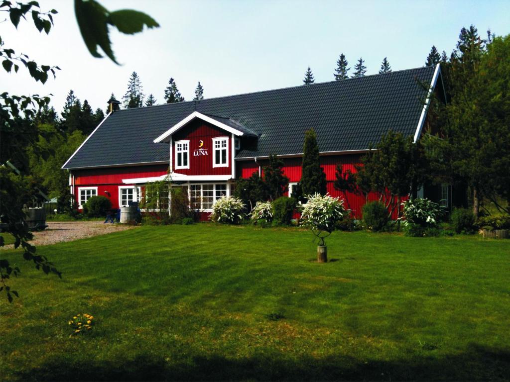 a red house with a green yard in front of it at Villa Luna Breakfast Hotel in Killeberg