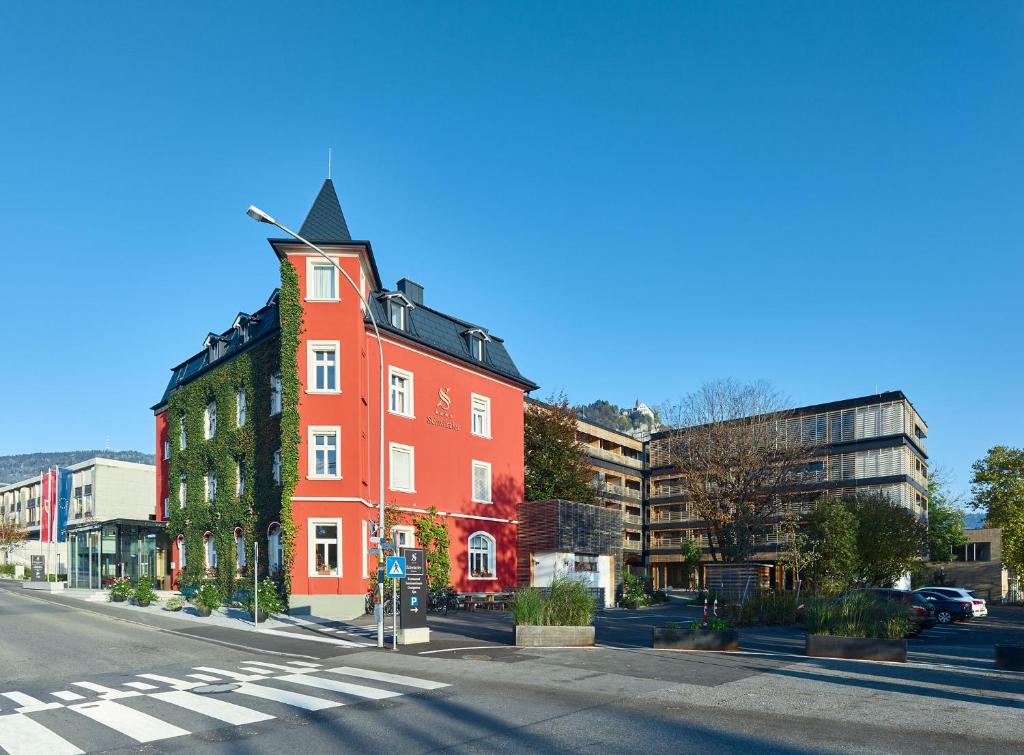 un bâtiment rouge sur le côté d'une rue dans l'établissement Hotel Schwärzler, à Bregenz