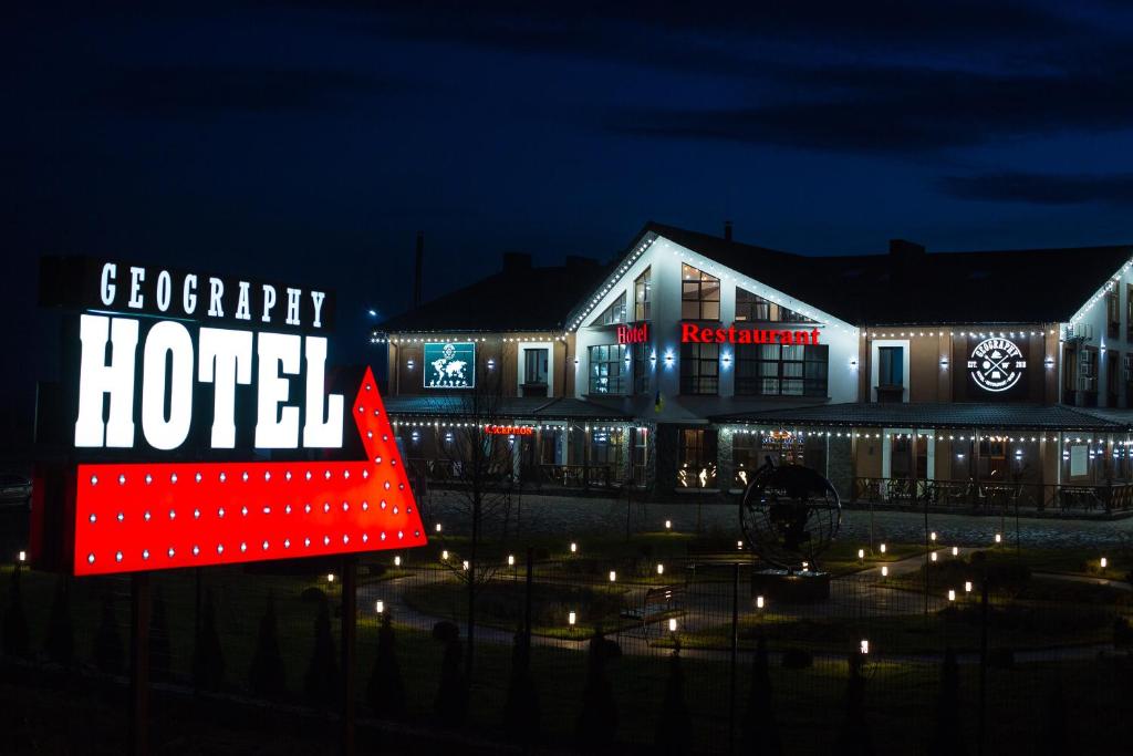 a hotel with a sign in front of it at night at Geography in Veresneve