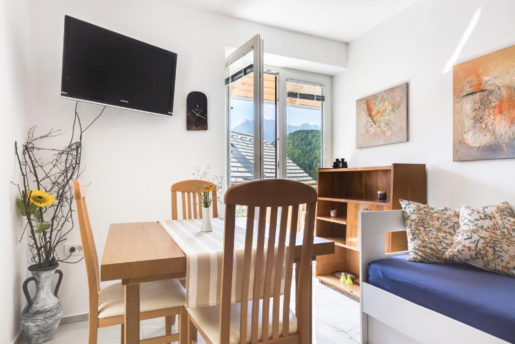uma sala de estar com uma mesa de jantar e uma televisão em Apartments Julian Adventure em Kranjska Gora