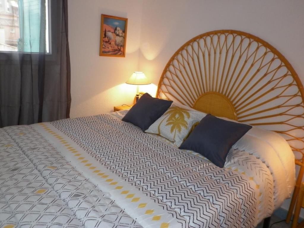 um quarto com uma cama grande e uma cabeceira em madeira em Villa climatisée 3 Pièces 100 m plage CAP D'AGDE em Cap d'Agde