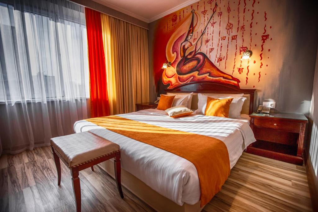 a bedroom with a large bed with a large painting on the wall at G Empire in Astana