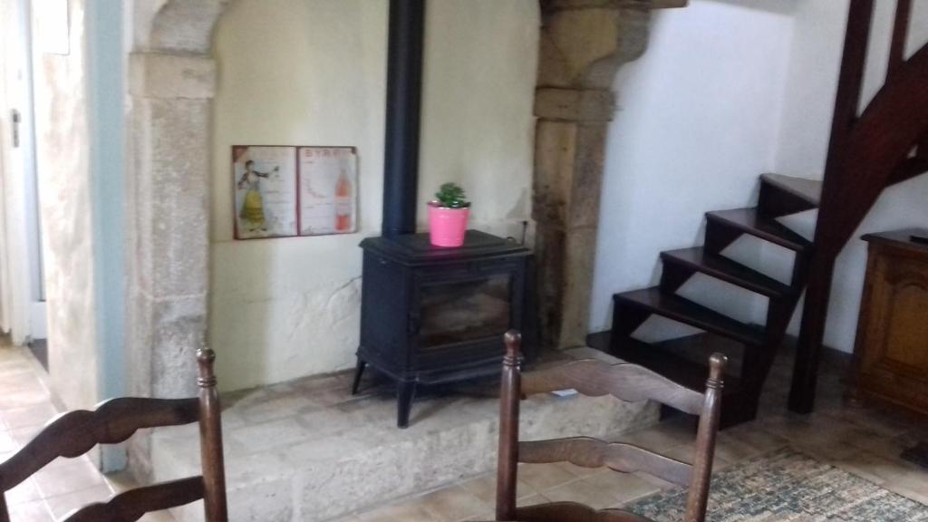 a living room with a stove and a staircase at LA LAMBERTERIE : LA BOULANGERIE in Yvetot Bocage