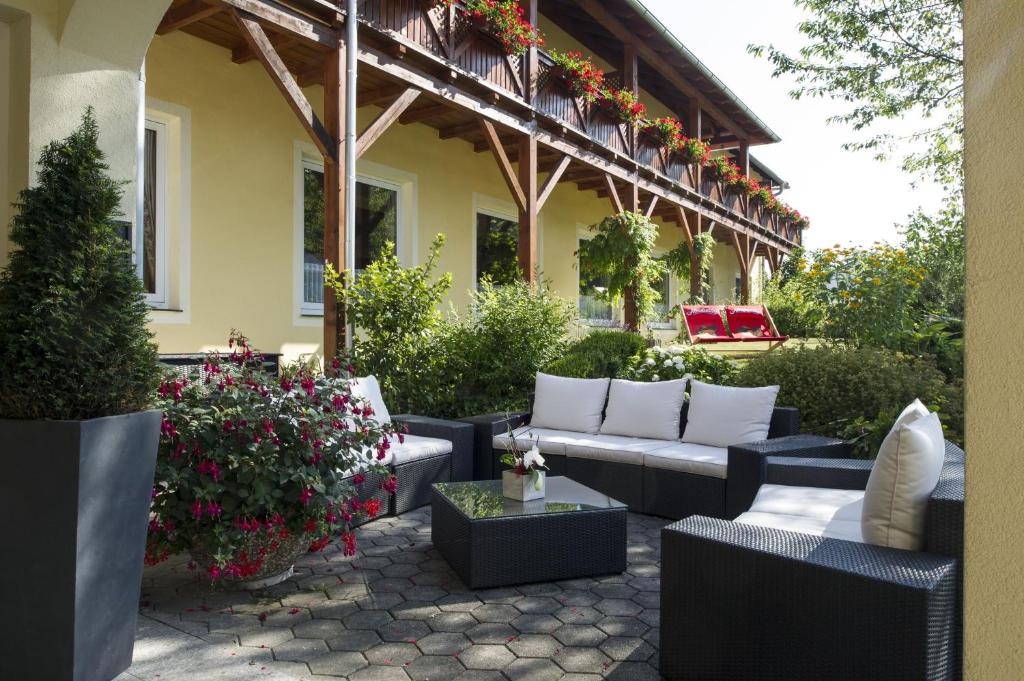 un patio con sofás y flores en un edificio en Der Dorfwirt, en Rechberg