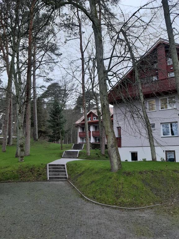 una gran casa blanca con techo rojo en Kalno namai - apartamentas Juodkrantėje en Juodkrantė