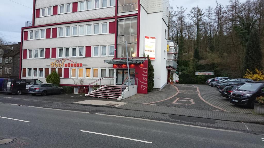 ein Gebäude an der Seite einer Straße mit geparkten Autos in der Unterkunft Hotel Bürger in Siegen