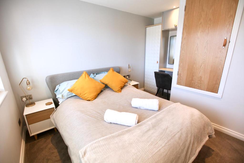 a bedroom with a bed with two towels on it at Stylish Cambridge Pad in Bar Hill 
