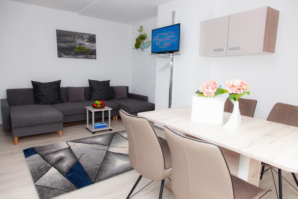 un soggiorno con tavolo e divano di T&K Apartments near Messe Fair Trade Düsseldorf und Airport 3A a Duisburg