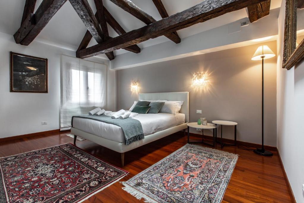 ein Schlafzimmer mit einem Bett und zwei Teppichen in der Unterkunft San Pantalon Luxury Penthouse R&R in Venedig