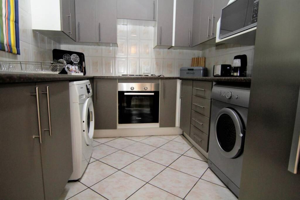 a kitchen with a washer and dryer in it at The Gatehouse in Alberton