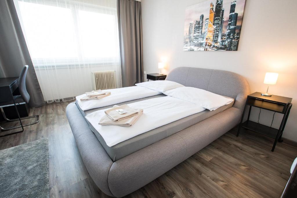 Un dormitorio con una cama con sábanas blancas. en A-Sport Hotel en Brno