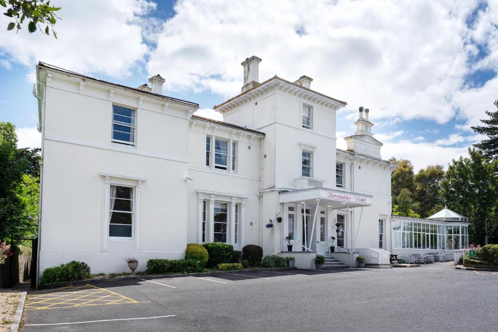 a white house with a driveway in front of it at Devonshire Hotel in Torquay