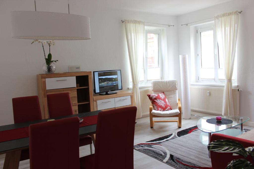 ein Wohnzimmer mit einem Tisch mit Stühlen und einem TV in der Unterkunft Weber Apartments in Dresden