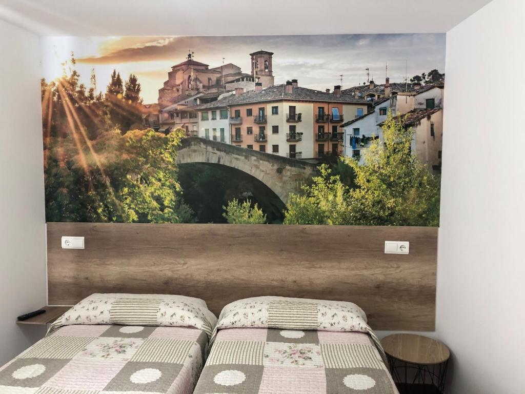 a bedroom with a wall mural of a bridge at Pensión Mavi in Los Arcos