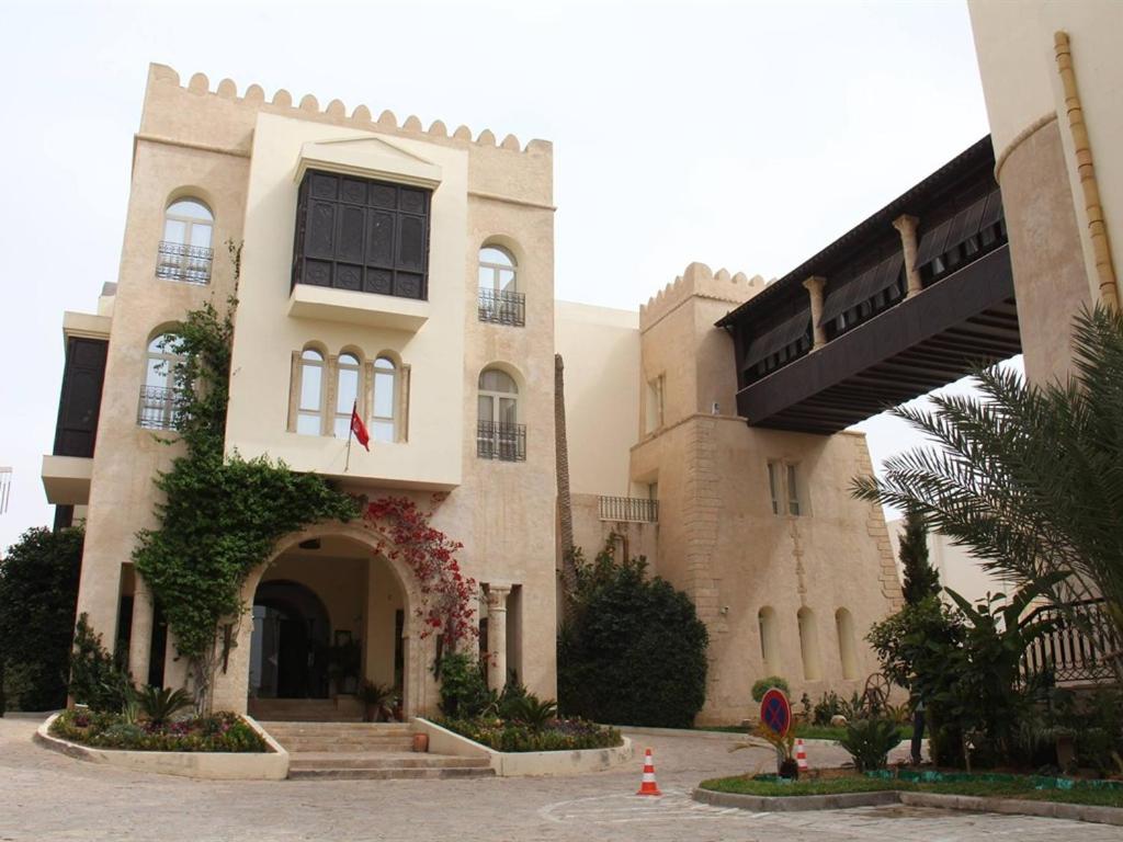 ein großes Gebäude mit einem Torbogen davor in der Unterkunft Borj Dhiafa in Sfax