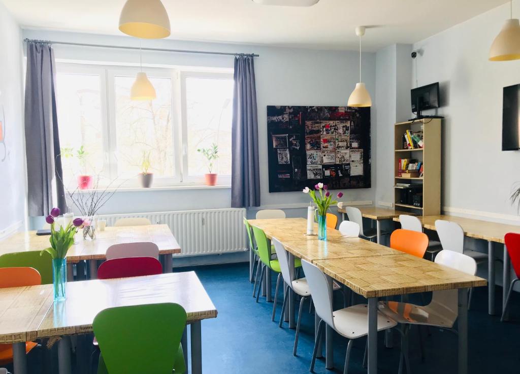 une salle à manger avec des tables et des chaises colorées dans l'établissement Hostel Inn-Berlin, à Berlin