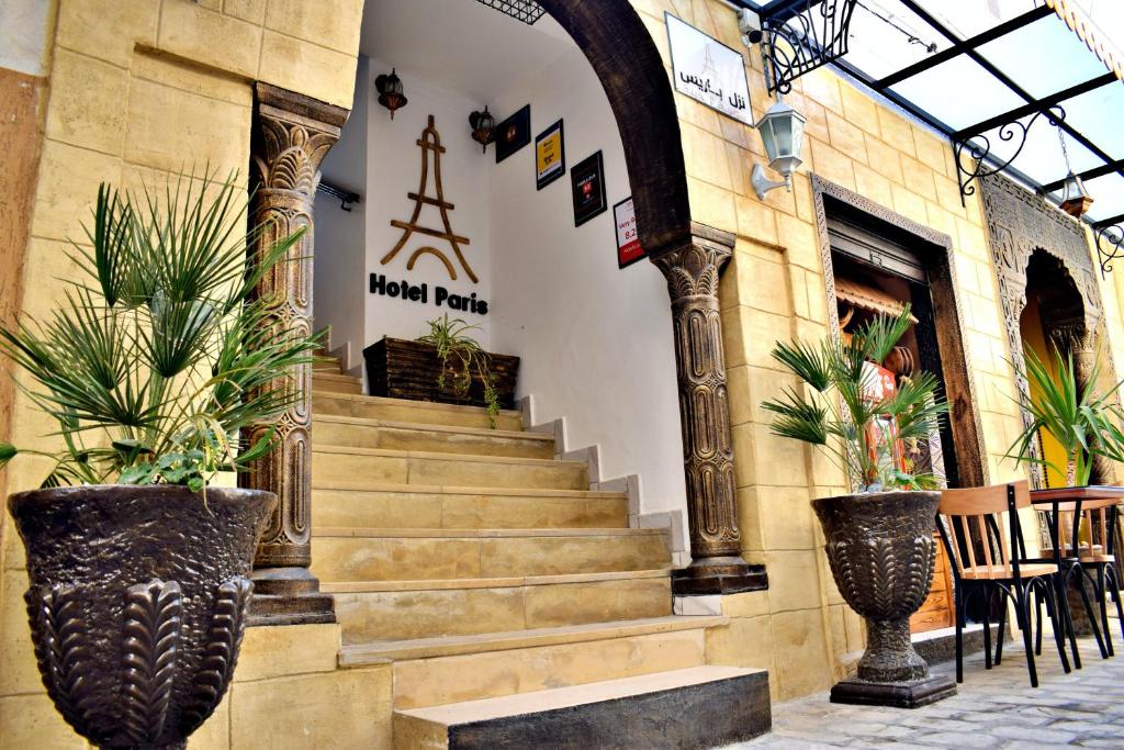 eine Treppe in einem Gebäude mit Topfpflanzen in der Unterkunft Hotel Paris in Sousse