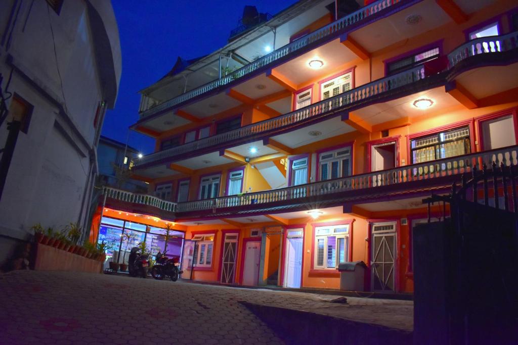 un grand bâtiment avec des lumières allumées la nuit dans l'établissement Hotel Santana, à Pokhara