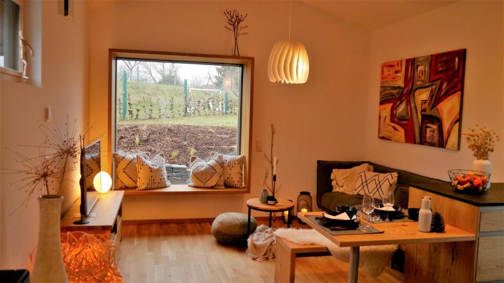 ein Wohnzimmer mit einem Tisch und einem Fenster in der Unterkunft Bio-Ferienhaus Newergarten in Wadern