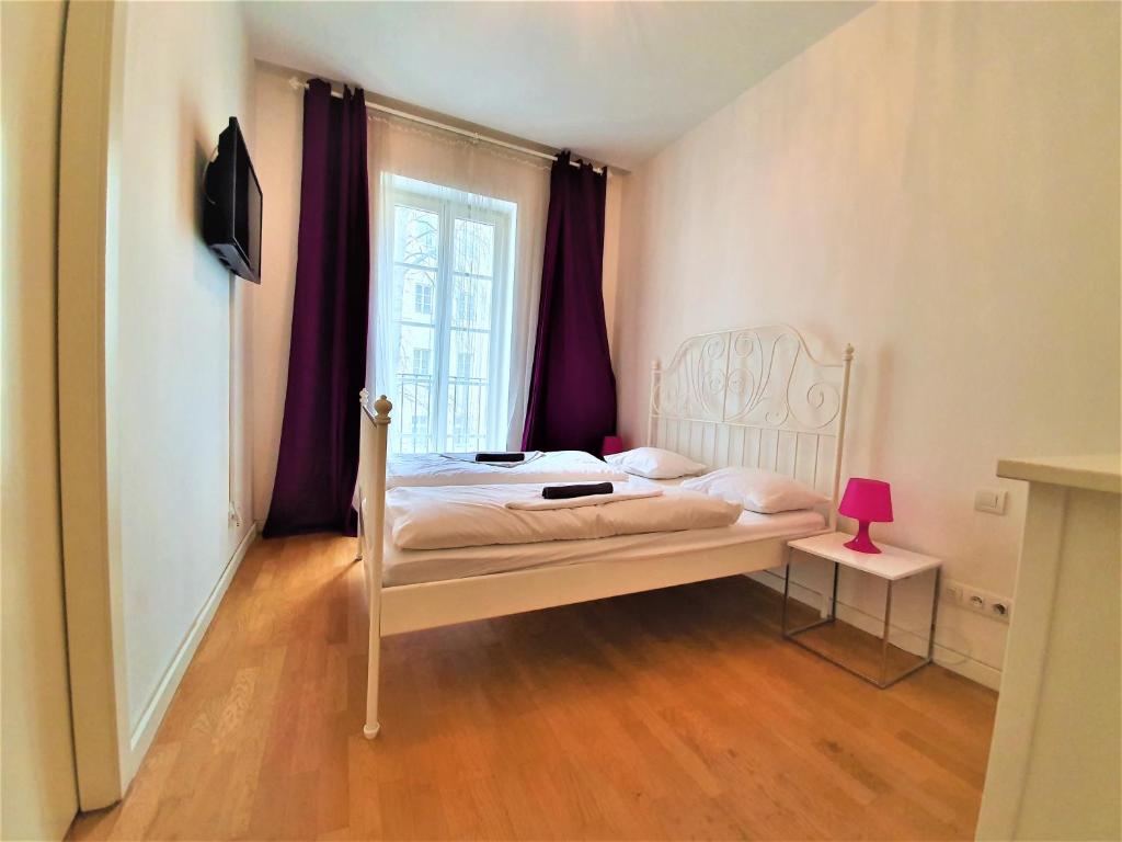 een kleine slaapkamer met een bed en een raam bij Apartment Sophia in Praag