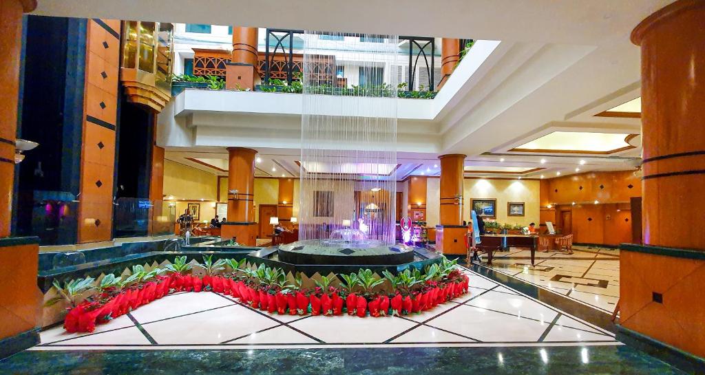 a lobby with red flowers in a large building at The Orchid Hotel Mumbai Vile Parle in Mumbai