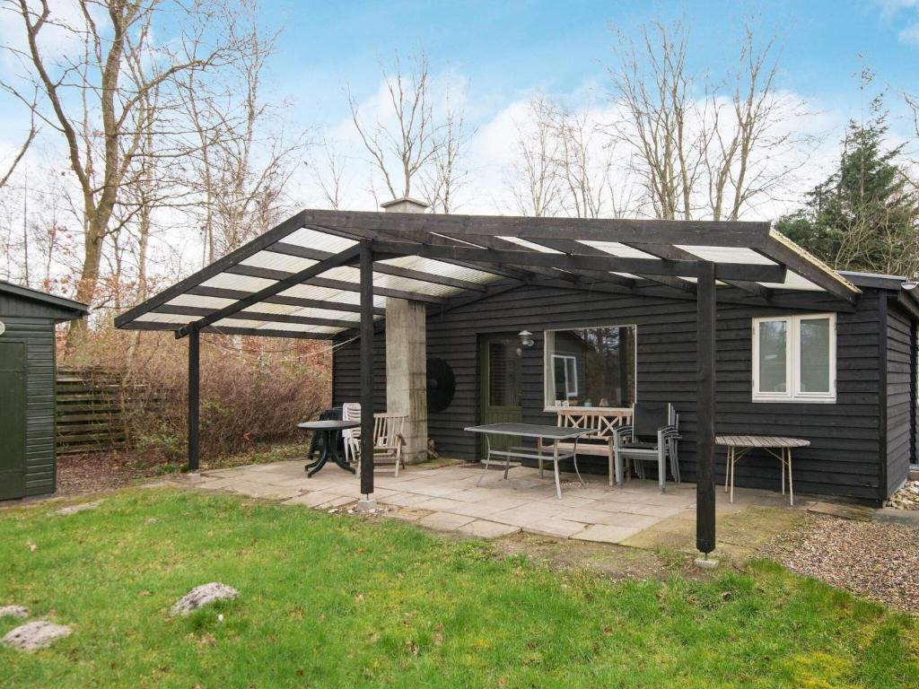 a black shed with a picnic table and a patio at 6 person holiday home in Glesborg in Glesborg