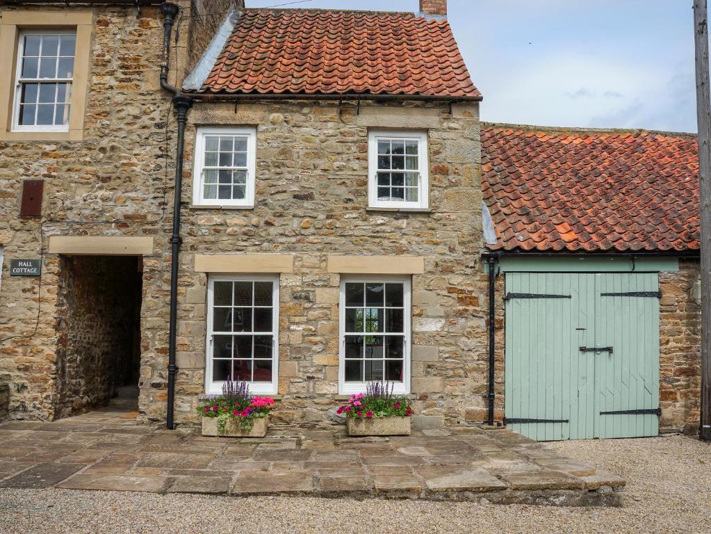 an old stone house with a green garage at Garden Cottage in Richmond