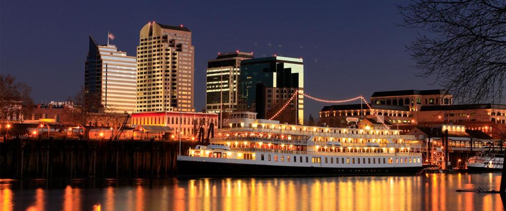 a large boat in the water in a city at night at Delta King Hotel in Sacramento