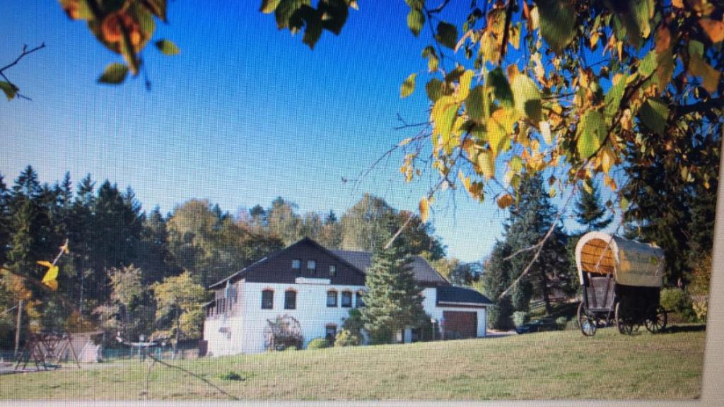 a field with a house and a bicycle in front of a house at Pension Haus Fürstenberg in Beierfeld