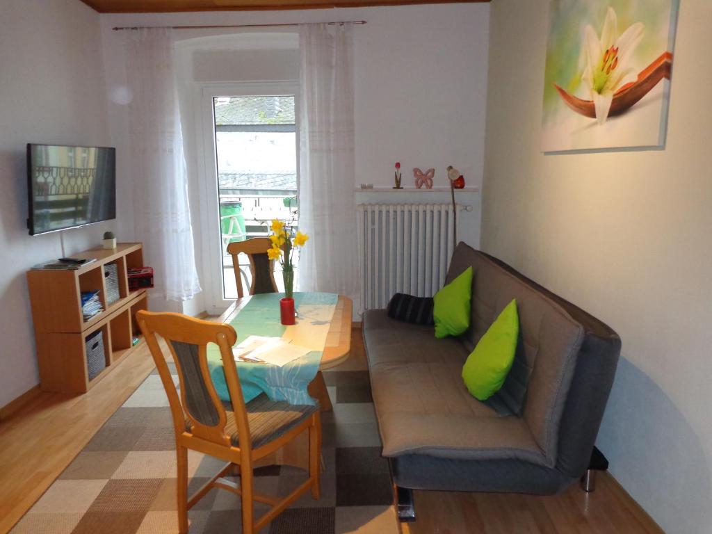 un soggiorno con tavolo e divano di Ferienwohnungen Leo Werland-Ehses a Zeltingen-Rachtig