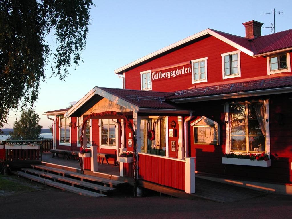 a red building with a restaurant in front of it at Tällbergsgårdens Hotell in Tällberg