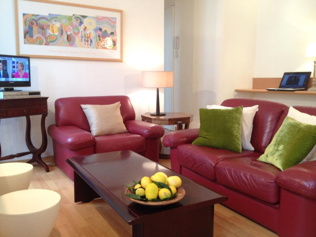 a living room with a red couch and a table at Appartements 7 Florian in Cannes