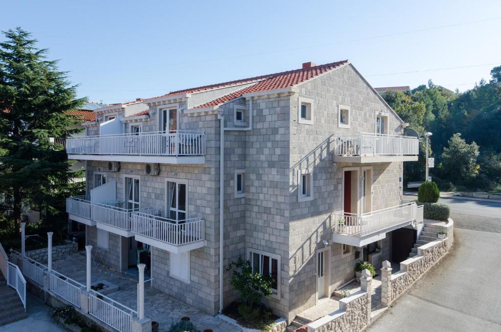 un gran edificio de piedra con balcones en una calle en Apartments Senjo en Cavtat