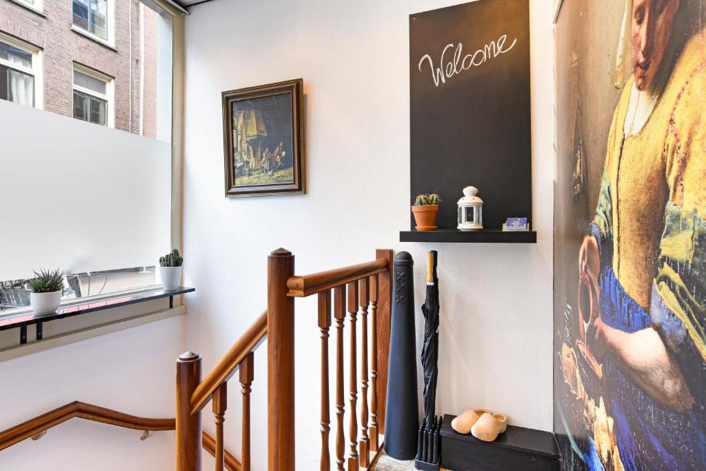 a stairway with a painting of a woman on a wall at Only Friends in Amsterdam