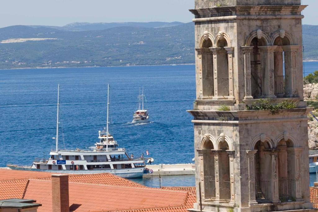 a clock tower and a boat in the water at ARGUSA4 in Makarska