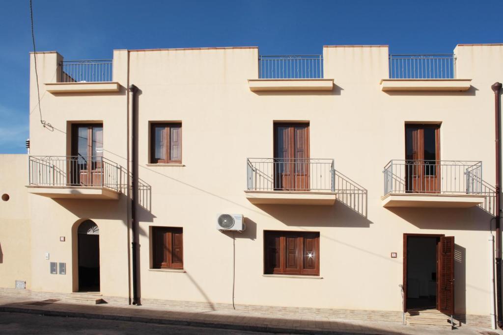 een wit gebouw met balkons in een straat bij Appartamenti Leone1 in San Vito lo Capo