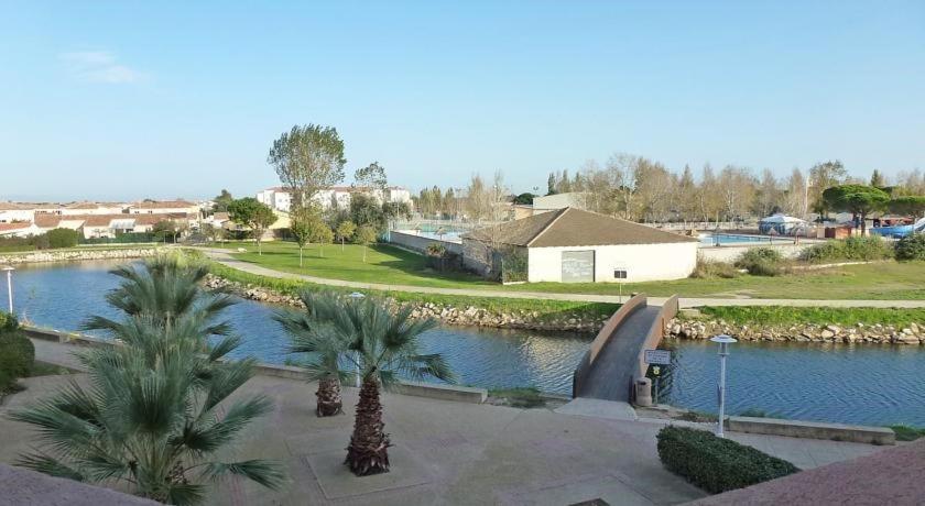 une rivière avec des palmiers et un skatepark dans l'établissement AS8314 - P2 Cabine dans une résidence avec piscine, parking privé et belle vue chenal, au Grau-du-Roi