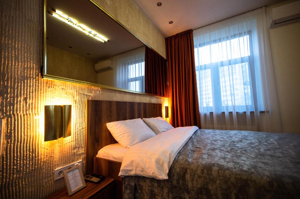 1 dormitorio con cama con espejo y ventana en Kyiv Panorama Apartments near Gulliver, en Kiev