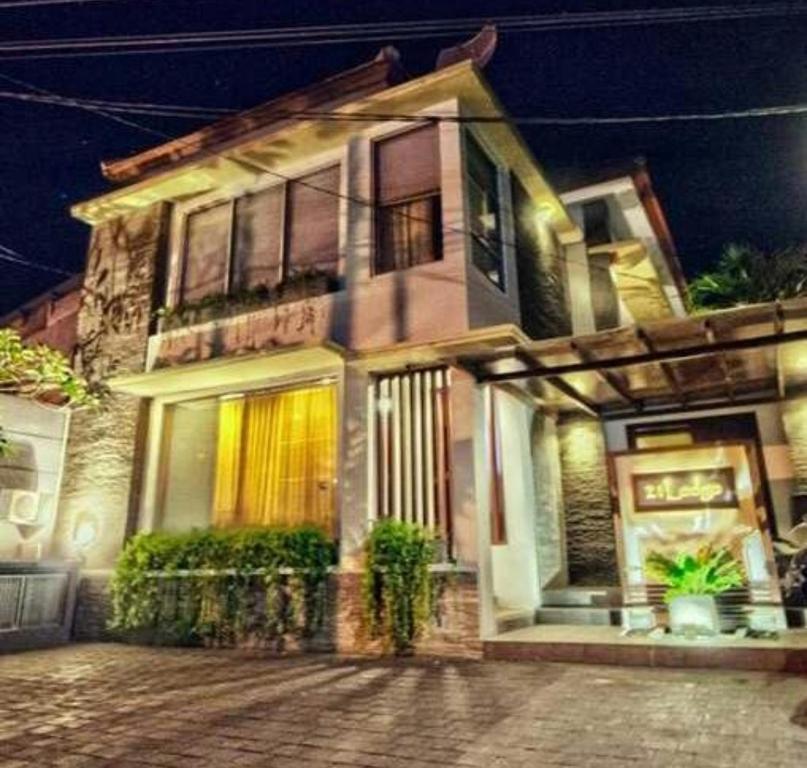 une maison en briques avec une terrasse couverte dans une rue la nuit dans l'établissement 21 Lodge, à Nusa Dua