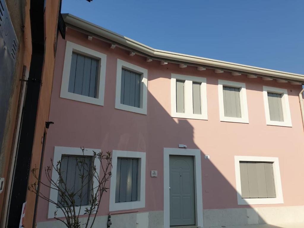 a pink building with a blue door at CORTE QUADRIFOGLIO in Verona