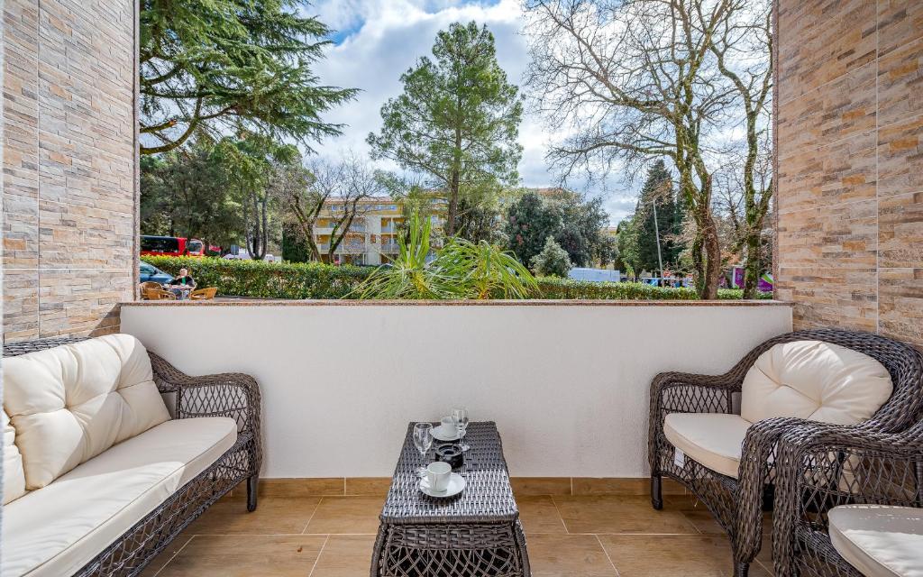 a patio with two wicker chairs and a table at Villa HEIDI in Umag