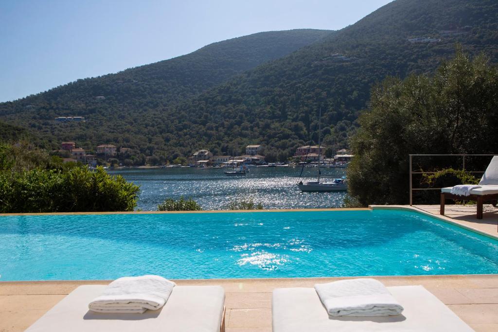 a swimming pool with a view of a lake and mountains at Arodo Seaside Villas - Villa Christina in Sivota
