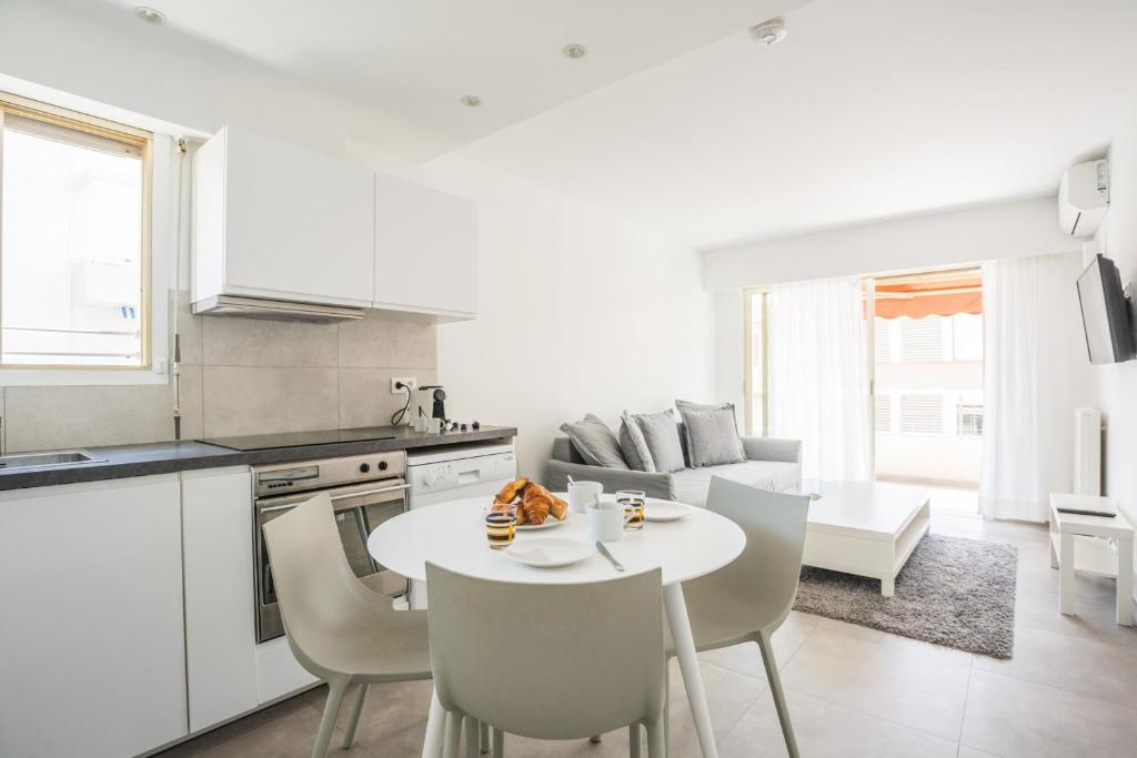 a kitchen and living room with a table and chairs at Bright One BDRM Apartment AC-Congress, Beaches by Olidesi in Cannes