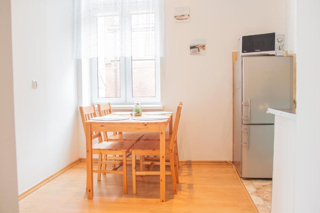 a kitchen with a table and chairs and a refrigerator at AL-DOM apartamenty Apartament Oliwia in Kołobrzeg