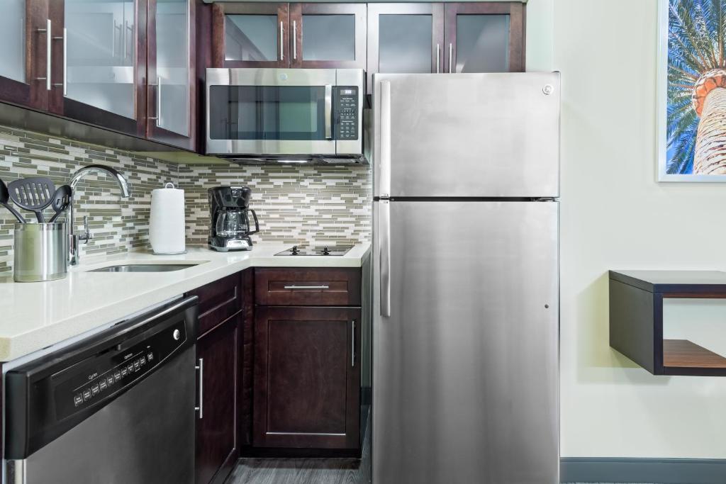 a kitchen with a stainless steel refrigerator and cabinets at Staybridge Suites - Miami International Airport by IHG in Miami