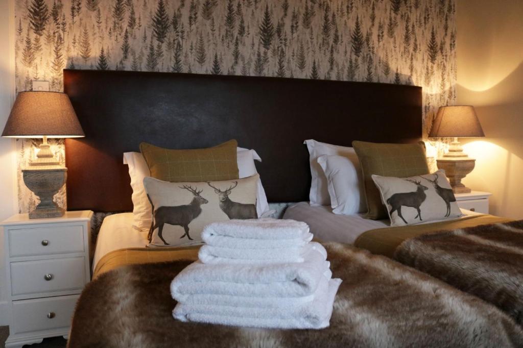a bedroom with two beds with towels on the bed at No12 Hotel in North Berwick