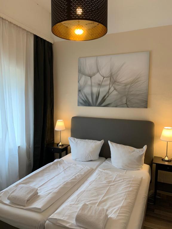 a bedroom with a large white bed with two pillows at Hotel Bee Fang in Hamburg